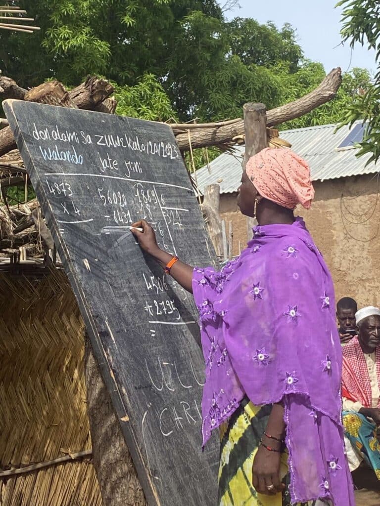 Häuser der Hoffnung - Frau aus Mali schreibt auf Tafel