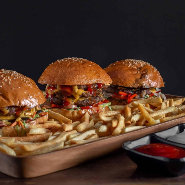 Tablett mit Burgern und Pommes als Symbolbild für Essstörung, verwendet auf einer Klinikseite über Hilfe bei Essattacken.